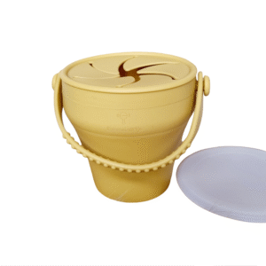Taza de silicona plegable con tapa para snacks en color ocre, ideal para niños pequeños.