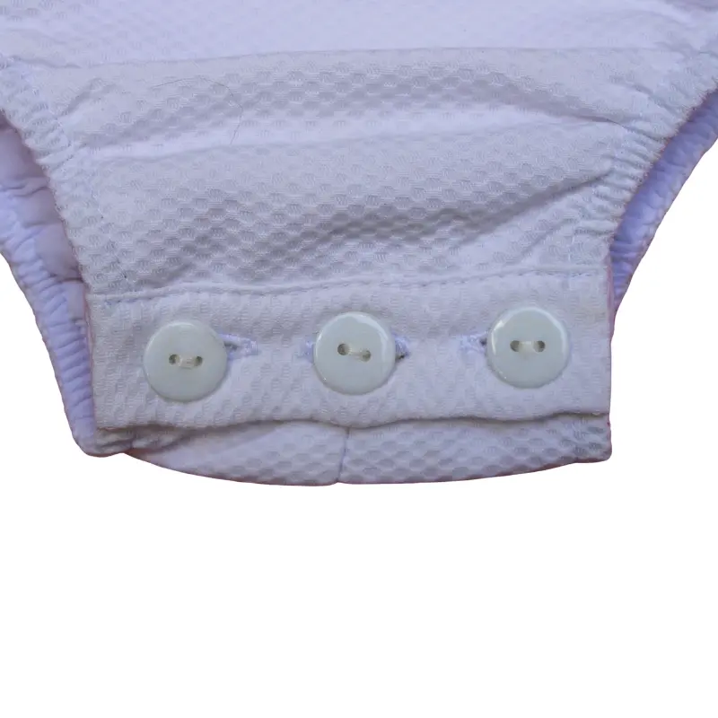 Enterizo plisado de color blanco con volantes rosas para bebé de Chocolat Baby