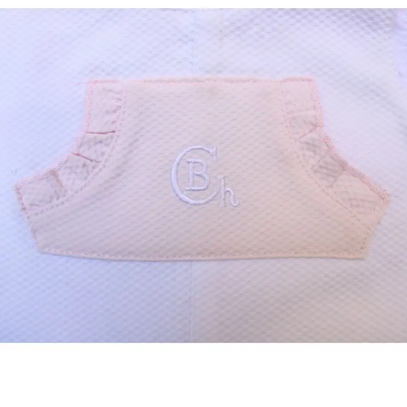 Mono bebé blanco y rosa Chocolat Baby vista delantera en detalle del bolsillo
