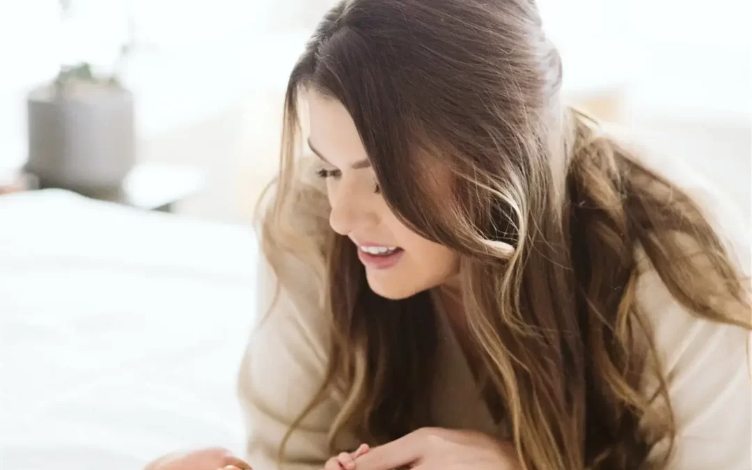 una mujer mirando a su hijo recién nacidotumbado en la cama